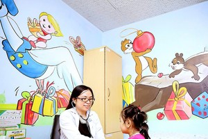 市医药大学医生为儿童检查及提供营养咨询。