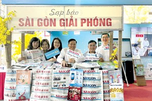 作者与报社领导和同事在《西贡解放报》参加二○二四年全国报刊展的展摊留影。