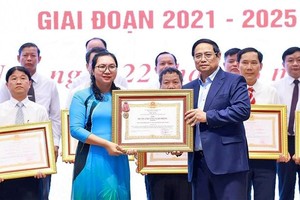 范明政总理向在“全民携手建设新农村”竞赛运动中取得突出成绩的地方授予奖状。