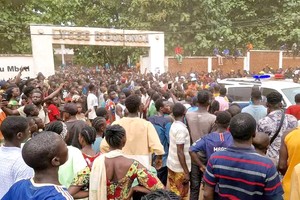 人们聚集在巴泰勒米‧博甘达中学门前。