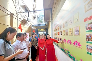 第二十九街区长周大伯（左二）与坊与居民配合建设胡伯伯文化空间。