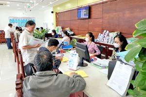 取消郡县级模式，增加坊乡级的权限，将有助于政府更接近人民，减少中间环节，更好地为人民服务。图为胡志明市干部、公务员为市民解决行政手续。