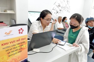 邮局员工辅助居民在滨城坊人委会线上递交卷宗。