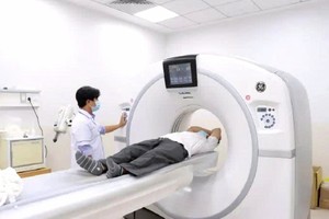 市肿瘤医院医生正在为病人进行核磁共振扫描。