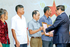 范明政总理向烈士家庭亲属代表颁授鉴定结果通报。