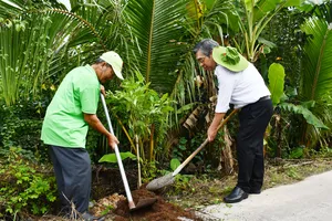 Đồng chí Nguyễn Phước Lộc trồng cây cùng người dân tại tuyến đường giao thông 