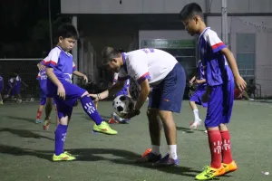 Lưu Ngọc Hùng với các học viên "nhí" trong buổi tập đầu tiên làm quen với bóng. Ảnh: Anh Trần