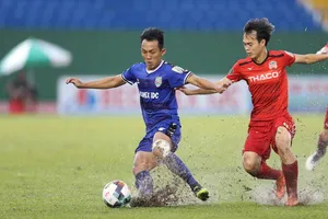 Văn Toàn bế tắc trước sự năng động của hàng thủ B.Bình Dương. Ảnh: DŨNG PHƯƠNG