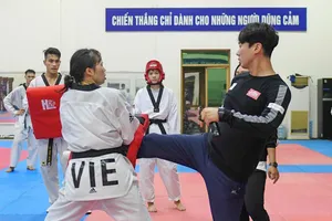 Chuyên gia Kim Kil-tae (phải) về nước trong ngày 26-7.