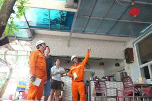Nhân viên viên ngành điện TPHCM tuyên truyền an toàn điện mùa mưa bão kết hợp khảo sát, tư vấn cho khách hàng (ẢNH: VIỆT HOA)