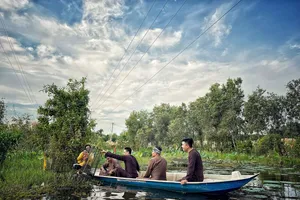 Du khách thích thú dỡ lợp bắt cá đồng tại Khu du lịch làng nổi Tân Lập (ẢNH: LÀNG NỔI TÂN LẬP)