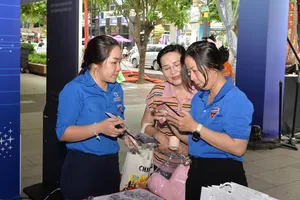 Nhân viên chăm sóc khách hàng của EVNHCMC hướng dẫn người dân cài đặt app