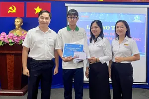 Ông Nguyễn Thanh Nhã, Phó Tổng giám đốc EVNHCMC và đại diện Công đoàn EVNHCMC trao học bổng đỡ đầu cho học sinh tại buổi lễ