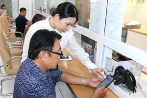 Nhân viên Công ty CP Cấp nước Nhà Bè hướng dẫn người dân thực hiện các giao dịch trên môi trường số