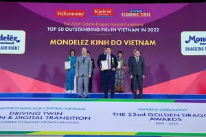 Ông Bùi Khánh Nguyên - Giám đốc Đối ngoại Công ty Mondelez Kinh Đô Việt Nam (giữa) nhận giải thưởng Rồng Vàng năm 2023 
