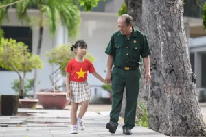 Thượng sĩ Nguyễn Chí Tường cùng con một nhân viên Vinamilk tại Trung tâm Điều dưỡng Thương binh và Người có công Long Đất. Ảnh: THANH BÌNH