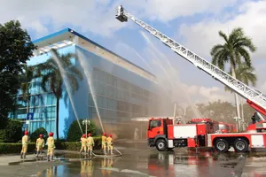 Lực lượng Cảnh sát PCCC-CNCH phối hợp với lực lượng PCCC cơ sở VWS triển khai phương tiện, phun nước từ xe thang trong tình huống diễn tập tại Khu liên hợp Đa Phước.