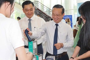 胡志明市人委会副主席裴明盛参观会议现场的产品展示及推介展位。图：黄雄