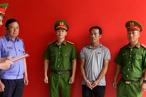 刘清平（右二）在调查机关。图：胡志明市公安