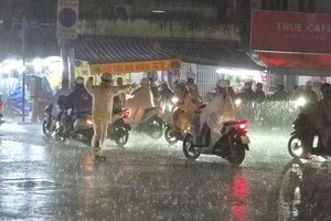 暴雨中，诺庄龙街—黎光定街交叉口交通信号灯停电，杭青交警冒雨到路口指挥交通。图：PC08