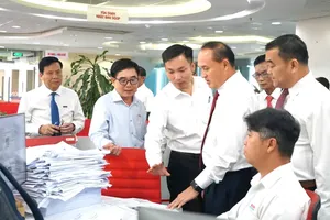 老挝干部代表团了解《西贡解放报》的出版工作。图：越娥