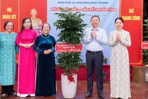 杨英德同志代表胡志明市市委、市人民议会、市人委会及胡志明市越南祖国阵线委员会赠送绿植，祝贺节日活动。图：红海