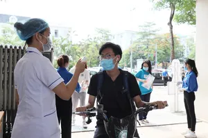 Đo thân nhiệt cho thí sinh. Ảnh: QUANG PHÚC 