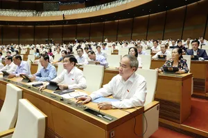 Đại biểu Quốc hội bấm nút biểu quyết thông qua luật. Ảnh: QUANG PHÚC