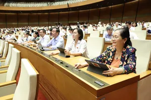 Đại biểu Quốc hội bấm nút biểu quyết thông qua luật. Ảnh: QUANG PHÚC