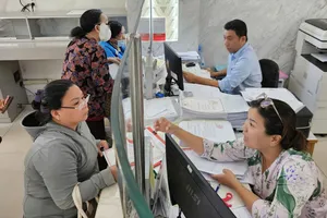 Công chức Trung tâm Phục vụ hành chính công phường Sài Gòn hướng dẫn người dân thực hiện thủ tục hành chính. ẢNH: NGÔ BÌNH
