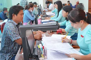 Công chức, viên chức Trung tâm Phục vụ hành chính công xã Vĩnh Lộc, TPHCM hướng dẫn người dân làm thủ tục hành chính. Ảnh: QUANG HUY