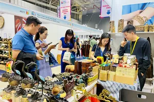 Khách tham quan tìm hiểu về các mặt hàng quà tặng tại hội chợ 