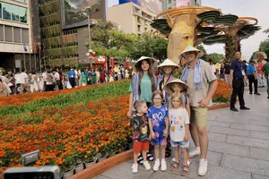 Du khách quốc tế tham quan đường hoa Nguyễn Huệ chiều 21-2