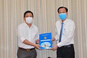 Phó Chủ tịch Thường trực UBND TPHCM Lê Thanh Liêm trao quyết định của UBND TPHCM về điều động đồng chí Trần Xuân Điền, Chủ tịch UBND quận 10, đến nhận công tác tại Thành ủy TPHCM. Ảnh: VIỆT DŨNG