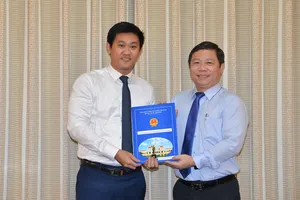 Phó Chủ tịch UBND TPHCM Dương Anh Đức trao quyết định cho đồng chí Hứa Quốc Hưng.Ảnh: VIỆT DŨNG