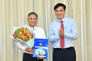 Phó Chủ tịch UBND TPHCM Lê Hoà Bình trao quyết định cho ông Lâm Hoài Anh. Ảnh: VIỆT DŨNG