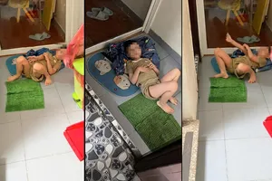 Hình ảnh bé trai nằm trên thảm lau chân trước nhà vệ sinh