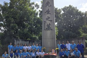 麦剑雄中学代表团在𦰡蓧坊广肇义祠麦剑雄墓碑前敬献鲜花。