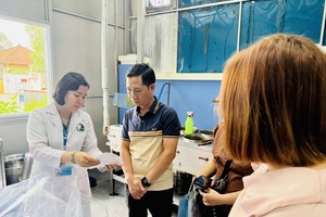 游客在胡志明市春和坊传统医药医院了解煎药流程。