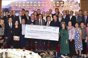 越柬寮世联会成员与南加州侨团代表将赈灾捐款支票面交越南驻美国三藩市总领事黄英俊（前排右八）合照。