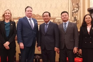 市人委会主席阮文得与美国驻越南大使马克·纳珀同与会代表合影留念。