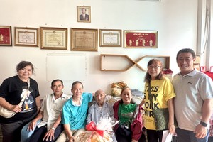 海南琼府会馆理事会代表团向华人革命老前辈韩晖光赠送新年礼物。