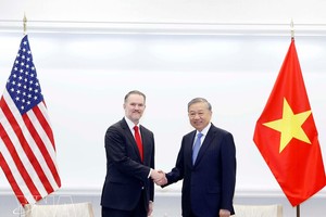 党中央总书记苏林与美国贸易代表贾米森·格里尔握手。图自越通社