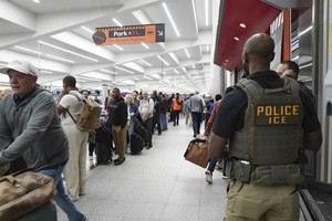 美国移民与海关执法局（ICE）人员于2026年3月23日在美国佐治亚州亚特兰大市哈茨菲尔德-杰克逊国际机场观察旅客。图源：GETTY IMAGES