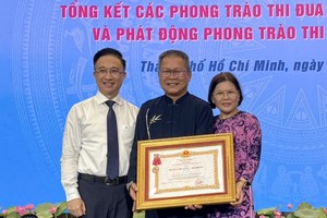 华人退休干部曾锦荣（中）荣获二等劳动勋章。