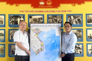 《西贡解放报》华文电子报采编部主任文忠孝（右）向穗城会馆理事长卢耀南赠送越南地图。