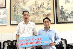 穗城会馆常值副理事长林海泉向本报领导文忠孝移交5000万元赞助经费。