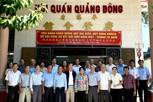 与会代表和嘉宾在胡志明市平阳广肇会馆前合影留念。