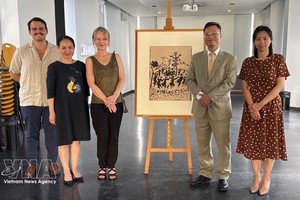 越南驻法国大使郑德海、保罗·艾吕雅艺术与历史博物馆馆长瓦莱丽·佩尔莱斯和越南代表团在《和平万岁》（Vive la Paix）画作原稿旁合影。