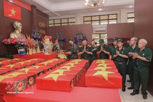 老战士们在胡志明市黎氏莲公园归集的烈士遗骸安放处默默缅怀战友。图自越通社